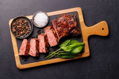 Mükemmel pişirilmiş çizgili biftek ve sulu, yumuşak bir arka plan. Biftek ve şarap aşıkları için gurme yemeği