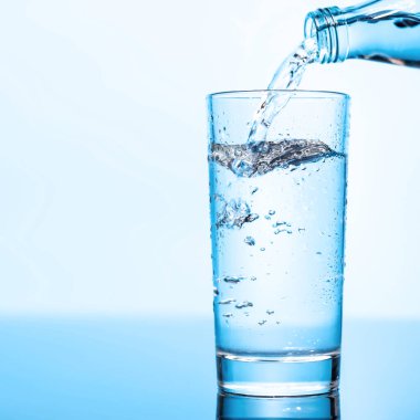 Şeffaf bardağa buzla doldurulan kristal berrak su canlandırıcı kabarcıklar ve kabarcıklar yaratır. Su ve saflığın mükemmel bir temsili.