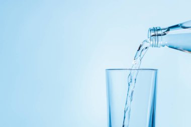 Şeffaf bir bardağa dökülen kristal berrak su canlandırıcı kabarcıklar ve kabarcıklar yaratır. Su ve saflığın mükemmel bir temsili.