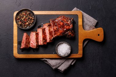 Mükemmel pişirilmiş çizgili biftek ve sulu, yumuşak bir arka plan. Biftek ve şarap aşıkları için gurme yemeği