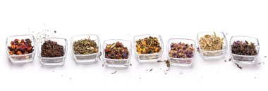 Çeşitli kuru çay yaprakları, farklı dokular, renkler ve karışımlar sergileniyor. Doğal ve aromatik çay çeşitlerinin mükemmel bir gösterisi. Rahatlatıcı ve lezzetli bir fincan demlemek için ideal.