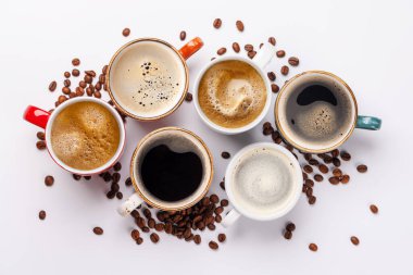 Zengin, aromatik kavrulmuş kahve çekirdekleri ile çevrili yeni demlenmiş bir kahve fincanı. Sıcaklığın, enerjinin ve kafeine olan sevginin mükemmel bir temsili.