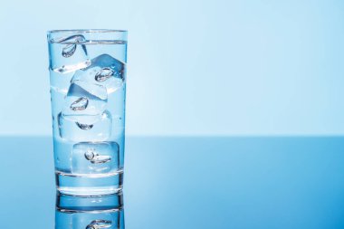 Buzlu su ve buz dolu berrak bir bardak ferahlatıcı ve serin bir içecek oluşturur. Susuzluğun ve tazeliğin mükemmel sembolü.