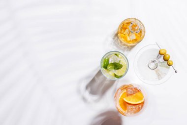 Parlak bir arka planda Aperol Spritz, Mojito ve Martini gibi canlı kokteyller sergilenmektedir. Karışımın ferahlatıcı ve renkli bir kutlaması