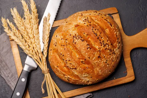 Bir somun taze ev yapımı ekmek. Altın kabuklu, yumuşak, havadar bir dokuya sahip. Sıcak ve davetkar bir koku yayıyor.