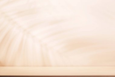 Boş masa ve duvarlı şablon doğal bitki gölgesi ve güneşli parıltı, ürün sunumu ve modelleme için mükemmel