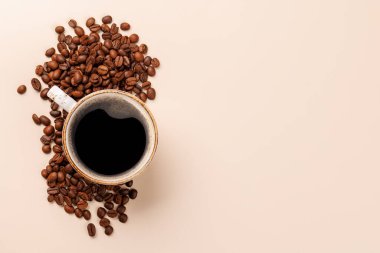 Zengin, aromatik kavrulmuş kahve çekirdekleri ile çevrili buharda pişmiş bir fincan taze kahve. Sıcaklığın, enerjinin ve kafeine olan sevginin mükemmel bir temsili.