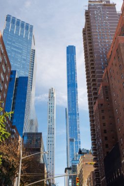 Manhattan 'ın ikonik gökdelenleri tarafından çerçevelenmiş New York şehrinin dinamik kentsel enerjisini ve mimari ihtişamını gözler önüne seren hareketli New York şehir merkezi caddesinin büyüleyici manzarası.