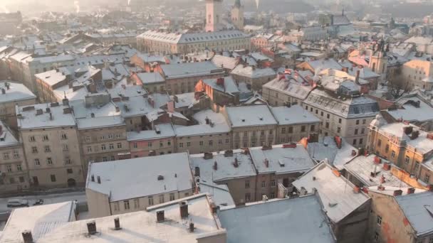 西ウクライナのリヴィウの街並みの空中ドローンビュー 雪に覆われた旧市街の映像をゆっくりと明らかにします 中央市場広場 市庁舎 旧教会 歴史的建造物 — ストック動画