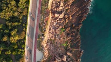 Cascais kasabasında, Lizbon, Portekiz 'de deniz kıyısındaki kayalık kıyıların hava aracı görüntüleri. Cascais şehrindeki doğal Boca do Inferno sınır işaretinin yakınındaki kıyı yolunun aşağı manzarası.. 