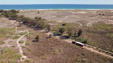 Ziyaretçileri anakaradan Portekiz 'in Tavira yakınlarındaki Barril plajına taşıyan trenin hava görüntüsü. Klasik Barril treni Algarve bölgesindeki Ria Formosa Ulusal Parkı 'ndan geçiyor.