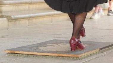 Seville, Endülüs, İspanya 'da geleneksel elbiseler içinde Flamenko dansı yapan bir kadın. Endülüs 'te sokak flamenko dansçılarının ayakları. Siyah etekli ve deri ayakkabılı bir kadın flamenko yapıyor..