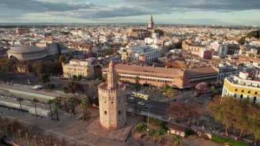 Torre del Oro kulesi, Katedral ve İspanya 'nın Endülüs bölgesinde günbatımında diğer tarihi binaları olan eski bir kasaba. İlkbaharda Sevilla şehir manzarasının hava aracı görüntüleri