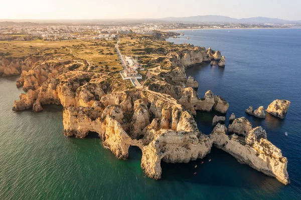 Güneş batarken Ponta da Piedade deniz fenerinin havadan görünüşü, Lagos kasabası, Algarve bölgesi, Portekiz. Farol da Ponta da Piedade Lagos 'un üst manzarası. Dik kayalıklar ve turkuaz su.