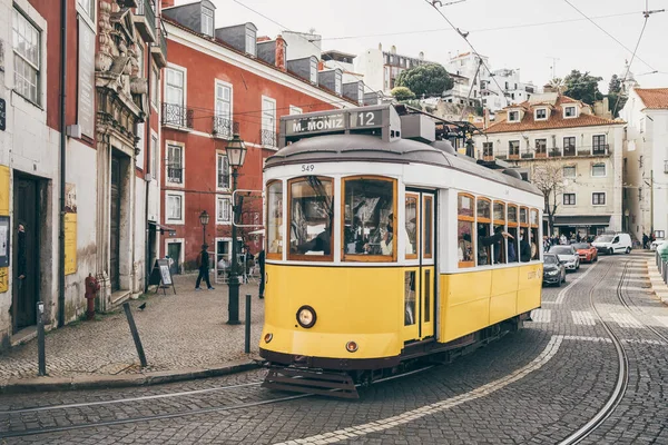 葡萄牙里斯本 2022年4月2日 葡萄牙里斯本鹅卵石街上的旧黄色复古电车 利斯波市的街景 传统的历史缆车载着乘客 — 图库照片