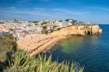 Carvoeiro fishing village with beautiful beach in Algarve, Portugal. View of beach in Carvoeiro town with colorful houses on coast of Portugal. Praia de Carvoeiro in Algarve