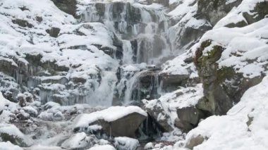 Karpat dağlarındaki güzel Shypit şelalesinin manzarası, kış manzarası. Ukrayna 'nın popüler turistik merkezi. Hala vurulmuş.