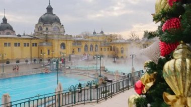 Szechenyi Hamamları kışın Budapeşte, Macaristan 'da. Avrupa 'da tarihi Macar termik banyosu. Szchenyi Hamamları 'nın balkonundaki Noel ağacı. Budapeşte 'de Noel ve yeni yıl tatili