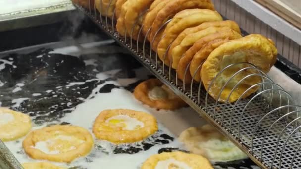 传统的匈牙利街头食品兰戈斯在集市上 兰戈斯在沸腾的油中油炸 油炸面包 布达佩斯圣诞市场传统的街头食品叫做Langos甜甜圈 — 图库视频影像