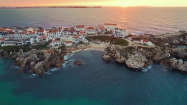 Günbatımında Portekiz 'in batı kıyısındaki Peniche kasabası yakınlarındaki Baleal yarımadasının hava manzarası. Portekiz 'deki Kayalık Baleal adasının insansız hava aracı görüntüleri. Portekiz gezileri ve sörf merkezleri. Yörünge atışı