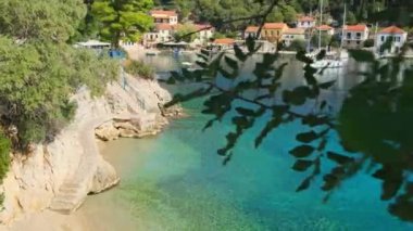 Ithaca adası, Kefalonia, İyon denizi, Yunanistan 'daki Kioni balıkçı köyünde küçük bir sahil. Ithaki 'deki Kioni köyünün deniz kenarındaki merdivenlerde. Cennet gibi Yunan adalarının manzarasını gözler önüne seriyor