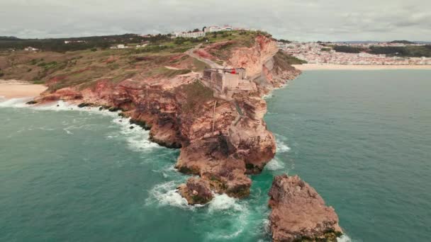 在葡萄牙纳扎尔镇 空中俯瞰着一座坐落在大西洋海岸一个堡垒上的悬崖上的旧灯塔 飞往葡萄牙纳扎尔市附近的灯塔 — 图库视频影像