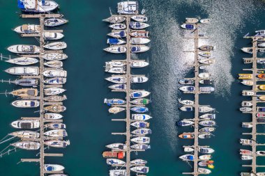 Yanaşmış yelkenlilerin yukarıdan görünüşü. Marinada demirlemiş beyaz tekne ve yatların havadan görünüşü. Limanda bir tekne. Tekneli liman