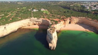 Portekiz 'in Algarve eyaletindeki Praia da Morena plajı. Güney Portekiz 'deki kayalık göldeki güzel plajın hava manzarası. Yörünge atışı
