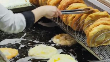 Geleneksel Macar sokak yemekleri Langos fuarında. Langolar kızgın yağda kızarıyor. Yağda kızartılmış ekmek. Budapeşte Noel Pazarı Langos çöreği adı verilen geleneksel sokak yemekleri