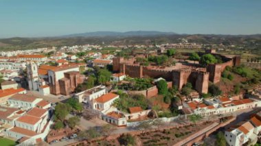 Portekiz 'in Algarve bölgesindeki ünlü ortaçağ şatosu ve katedrali olan Silves kasabasının hava manzarası. Silves Katedrali 'nin ve tarihi kalenin üzerinde uçuyor..