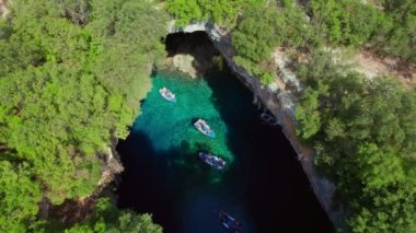 Yunanistan 'ın Kefalonia adasındaki ünlü Melissani Gölü. Yunanistan 'ın Kefalonya adasındaki Karavomylos köyündeki Melissani Mağara Gölü' nün havadan görünüşü. İnsansız hava aracı görüntülerini büyüt