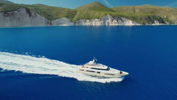 在希腊凯法利尼亚伊萨卡岛附近的爱奥尼亚深蓝色海 一艘豪华游艇全速前进的空中无人驾驶图像 无人机跟踪射击 — 图库视频影像