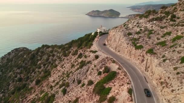 高崖とケファロニア島 ギリシャのターコイズブルーの海の水と美しい海岸沿いの道路を運転車の空中ビュー ターコイズブルーの水で美しい海の海岸のドローン映像を明らかに — ストック動画