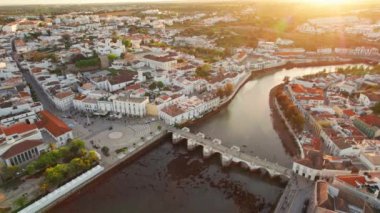 Sabah güneşinde Portekiz 'in Tavira şehrinin merkezi. Güneş doğarken eski Tavira kasabasının havadan görünüşü, Algarve bölgesi, Portekiz. Merkez Meydanı, Ponte Romana Köprüsü ve tarihi binalar.
