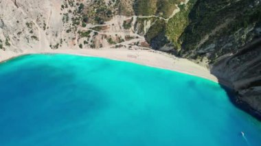 Kefalonia adasındaki ünlü Myrtos plajı, İyon denizi, Yunanistan. Yunan adasında güneşli bir günde popüler Myrtos plajının hava manzarası. Yörünge drone atışı. 