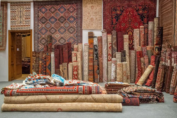 Variety of the gorgeous oriental carpets in traditional carpet store in Middle East. Pile of beautiful handmade carpets on the traditional Middle East market bazaar.