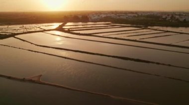 Portekiz, Tavira 'daki Ria Formosa gölündeki tuzlu bataklıklar. Algarve bölgesindeki Gilao nehri yakınlarında tuz üretimi. Tuz tarlasının hava aracı görüntüleri Güney Portekiz, Tavira yakınlarında.