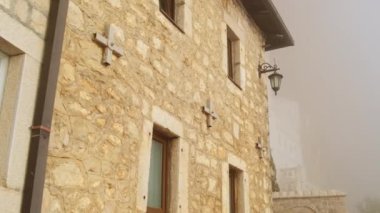 Ostrog monastery in Montenegro. Church of the Holy Cross in rock. Ostrog ortodox monastery in morning fog. Ostrog monastery is the most popular pilgrimage place in Montenegro.