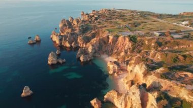 Praia do Camilo beach near Lagos town, Algarve province, Portugal. Beautiful Algarve sea coast at sunrise. Aerial view of the white sand beach in rocky lagoon.