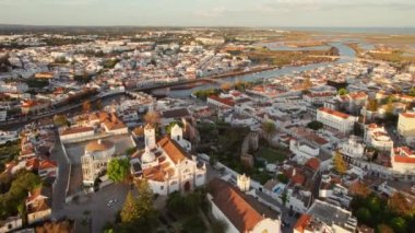 Sabah güneşinde Portekiz 'in Tavira şehrinin merkezi. Güneş doğarken eski Tavira kasabasının havadan görünüşü, Algarve bölgesi, Portekiz. Merkez Meydanı, Ponte Romana Köprüsü ve tarihi binalar.