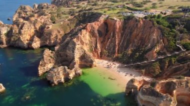 Praia do Camilo beach near Lagos town, Algarve province, Portugal. Beautiful Algarve sea coast at sunrise. Aerial view of the white sand beach in rocky lagoon.