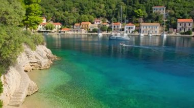 Picturesque Kioni fishing village on the Ithaca island, Kefalonia, Ionian sea, Greece. Stairs by the sea in Kioni village on Ithaki. Still shot of the sail boat moored in idyllic Greek village. 
