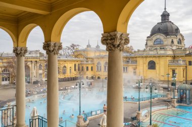 Budapest, Hungary - November 21, 2022: Szechenyi Baths in Budapest in winter, Hungary. Historic Hungarian thermal baths in Europe. People enjoying thermal baths in Budapest. clipart