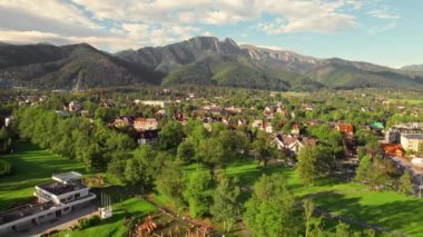 Tatra dağları olan Zakopane kasabasının hava aracı görüntüsü yaz mevsiminde Polonya 'nın arka planında. Polonya 'da halk yürüyüşü ve doğa severler var. Zakopane tatil köyü ve yüksek Tatra dağları