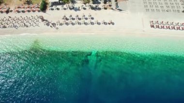 Yunanistan 'ın Kefalonia adasındaki Antisamos plajında kristal berraklığında masmavi bir su. Yunanistan 'ın İyon Adası' ndaki Kefalonia Adası 'nda güneşli yataklı cennet sahili manzarası. Açılış vuruşu
