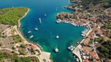 Aerial view of the picturesque Fiskardo village and port Kefalonia island, Greece. Sail boats and yachts moored in traditional fishing village of Fiscardo, Cefalonia, Greece. Drone orbit shot