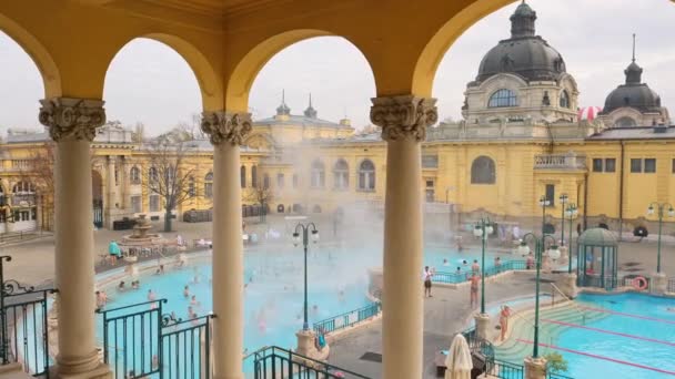 ブダペスト ハンガリー 2022年11月21日 ハンガリーの冬にブダペストのSzechenyi風呂 ヨーロッパの歴史的なハンガリーの温泉 ブダペストで温泉を楽しむ人々 スローステディカムショット — ストック動画