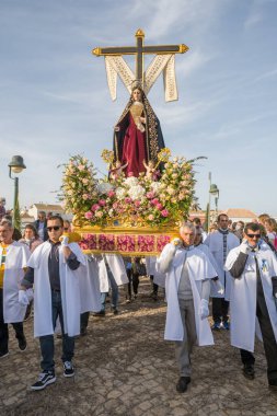 Tavira, Portekiz - 10 Nisan 2022: Portekiz 'in Algarve bölgesinde Paskalya öncesi Pazar günü Palm Sunday' de Zafer Yürüyüşü. Tavira üzerinden İsa 'nın heykelini taşıyan kimliği belirsiz insanlar.