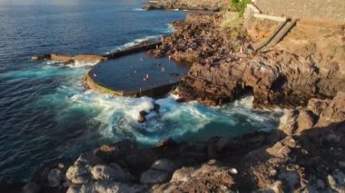 Los Gigantes 'in Tenerife, Kanarya Adası' ndaki tatil köyünün havadan görünüşü. Doğal havuz üzerinde uçmak, lüks oteller ve villalar ve arka planda Los Gigantes dağları. İHA görüntüleri gösteriliyor