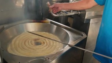 Tenerife 'de taze churro üretimi, Kanarya Adaları, İspanya. Sokak yemekleri satıcısı churros hazırlıyor hamuru kızgın yağın içine sıkıştırıyor. Churros İspanyol geleneksel fast food..